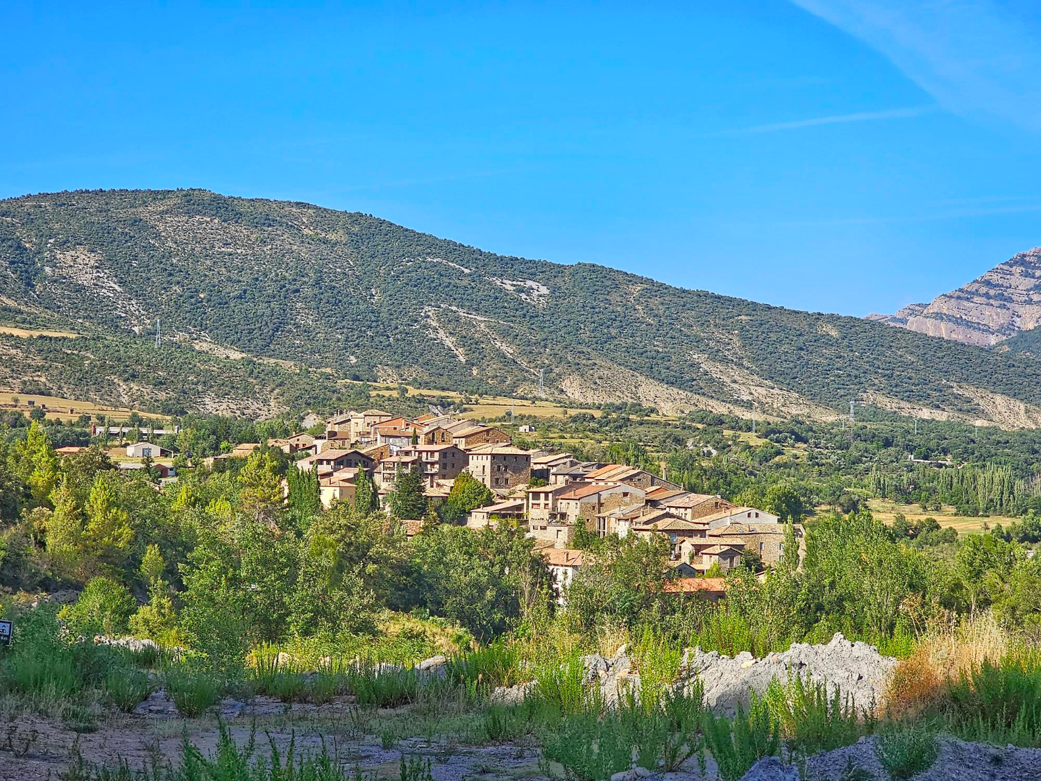 vue sur un petit village ensoleillé entouré de montagnes